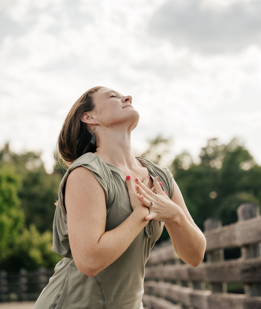 A woman with her hands over her heart in a moment of worship