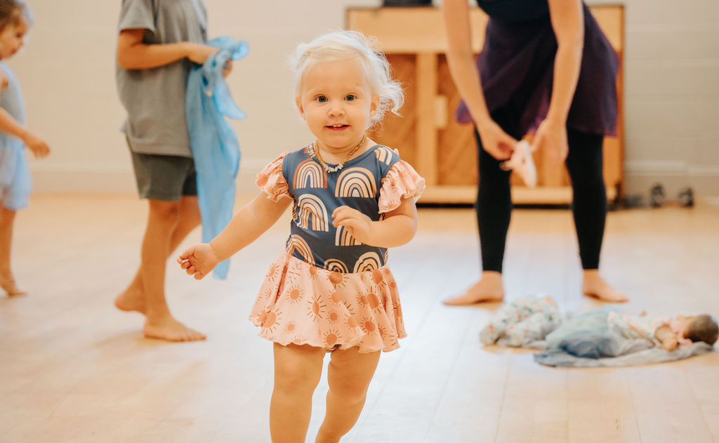 A toddler dancing across the studio floor