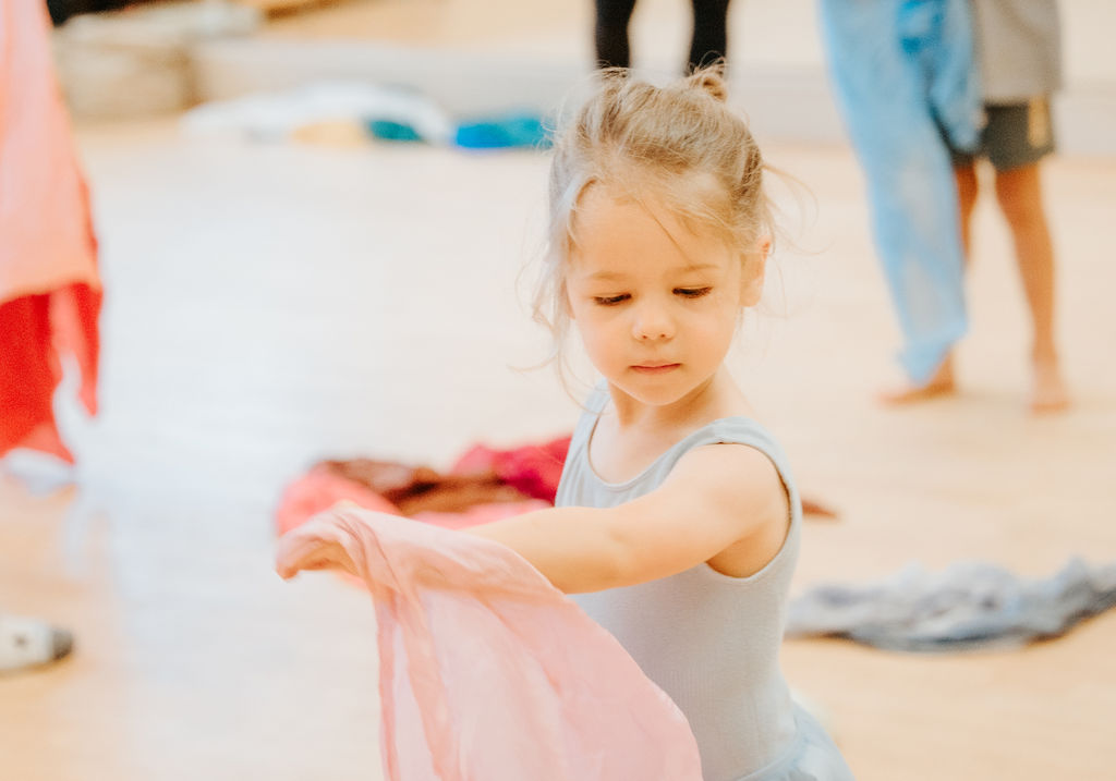 A girl sweeping a scarf through the air in class