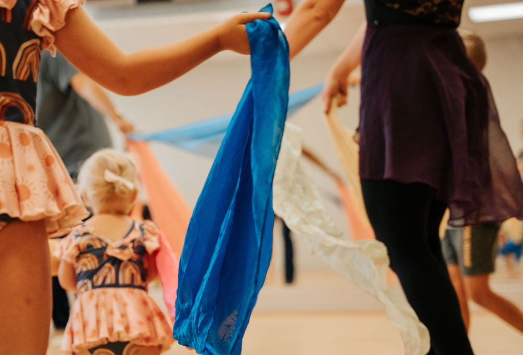 Young dancers playing with coloured silks in class
