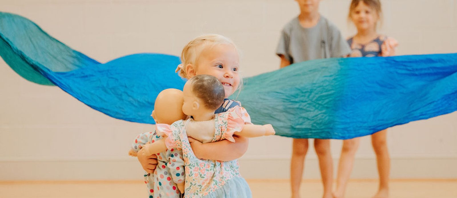 A small dancer smiling with her doll during class