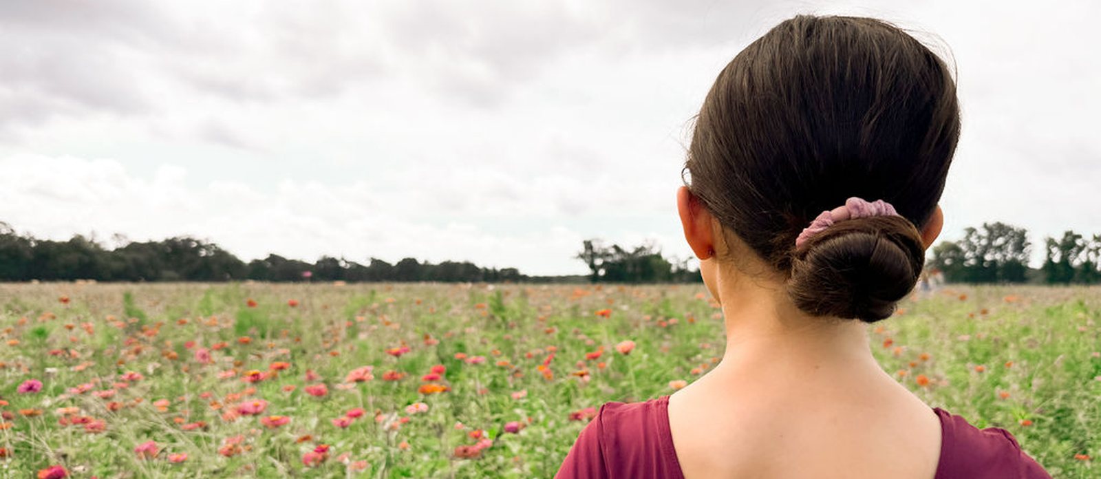A dancer looking out over a field of zinnias